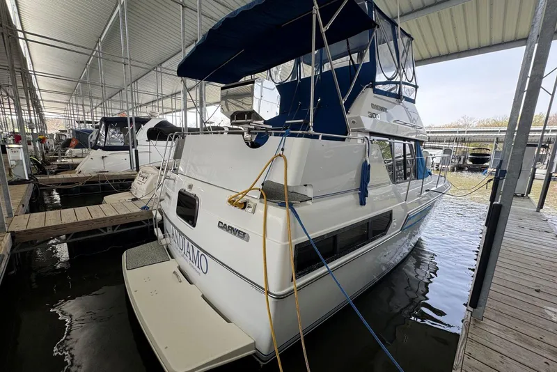 Slide: The Image of 1993 Carver 300 Aft Cabin yacht docked in a covered marina. - 5
