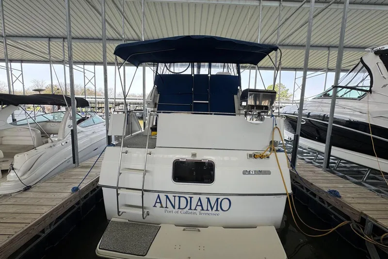 Slide: The Image of 1993 Carver 300 Aft Cabin boat docked, featuring "Andiamo" on the stern. - 6