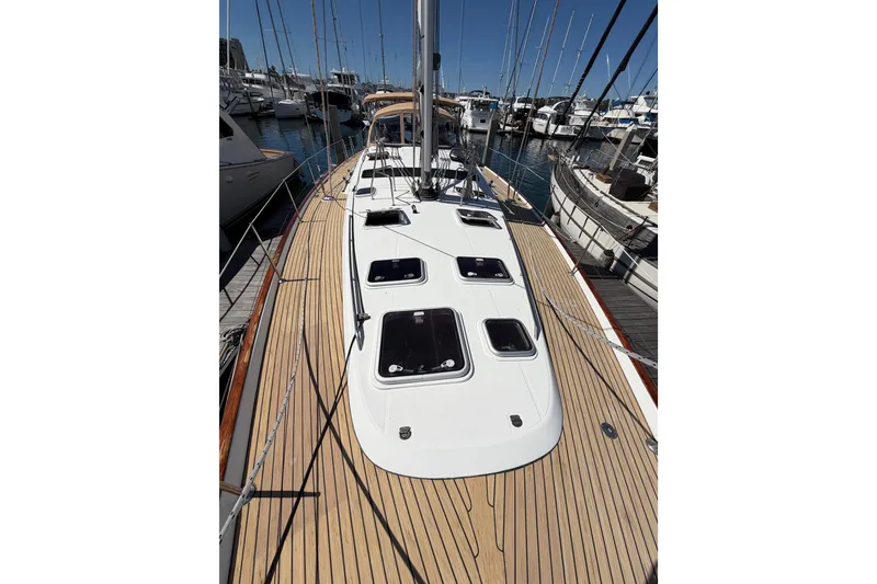 Slide: The Image of 2006 Beneteau Oceanis 523 sailboat docked at marina, showcasing teak deck and hatches. - 23