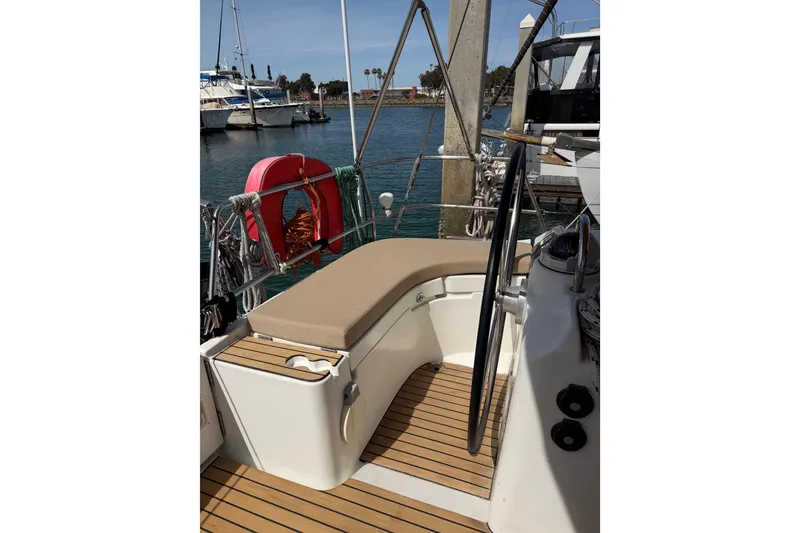 Slide: The Image of Cockpit of 2006 Beneteau Oceanis 523 sailboat with teak flooring and cushioned seating. - 26
