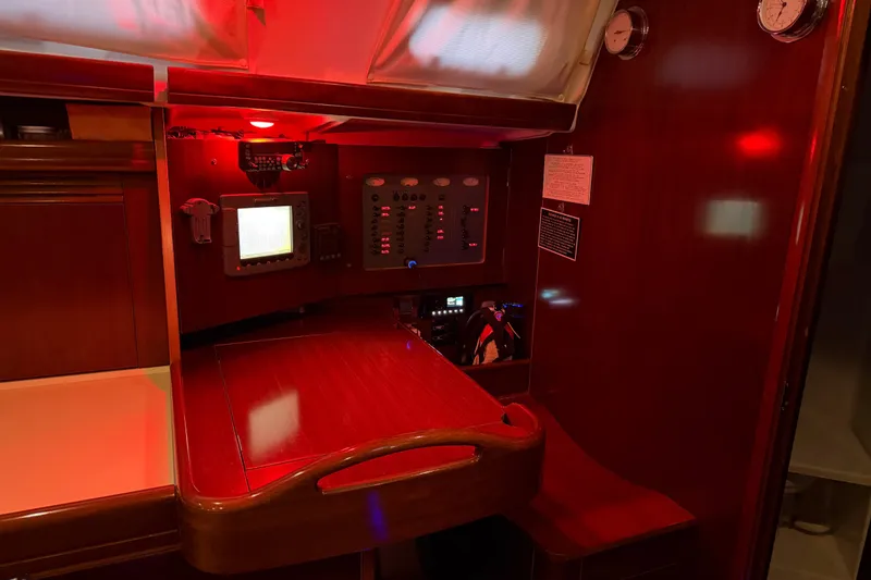 Slide: The Image of Navigation station of 2006 Beneteau Oceanis 523 yacht with red lighting and control panel. - 32