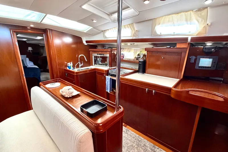 Slide: The Image of Interior of 2006 Beneteau Oceanis 523 yacht, featuring elegant wood cabinetry and modern amenities. - 33