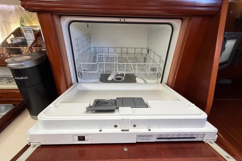 Slide: The Image of Built-in dishwasher on 2006 Beneteau Oceanis 523 yacht, featuring wooden cabinetry and modern appliances. - 36