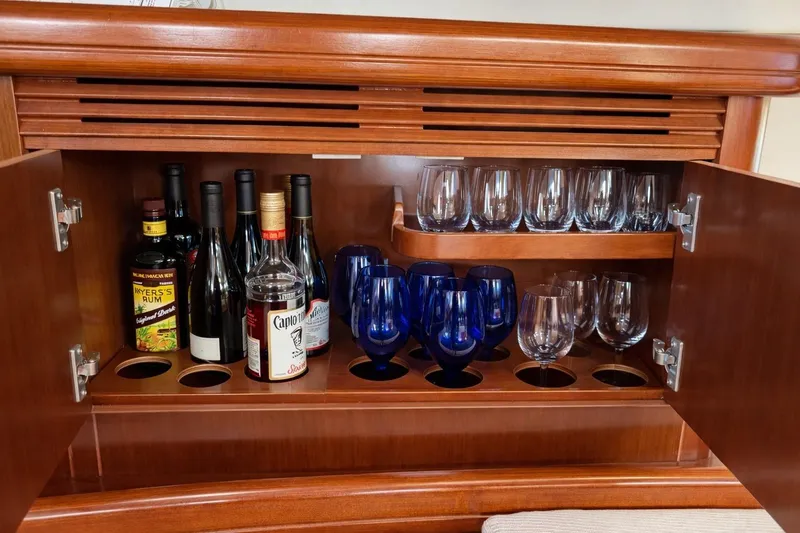 Slide: The Image of Bar cabinet on 2006 Beneteau Oceanis 523 yacht with bottles and glasses neatly arranged. - 42