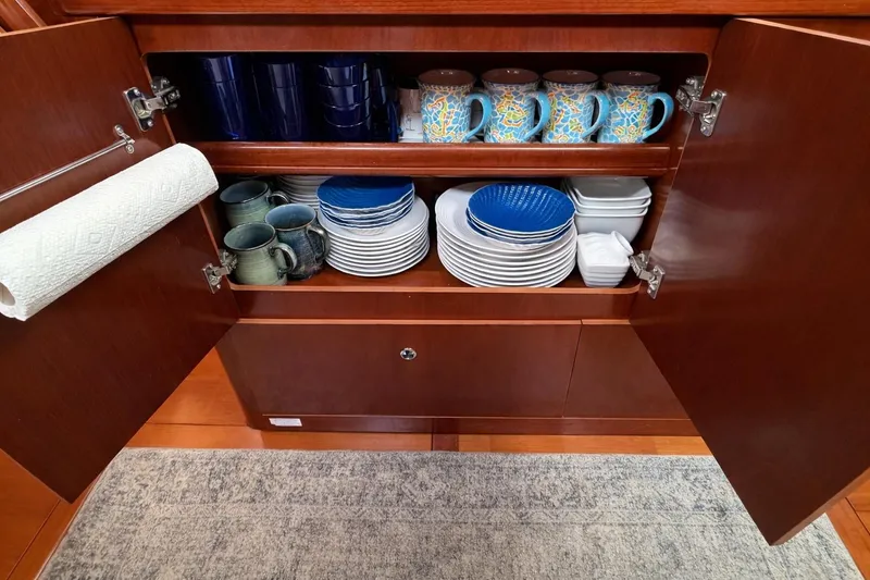 Slide: The Image of Open cabinet with dishes and mugs on a Beneteau Oceanis 523 yacht, 2006 model. - 47