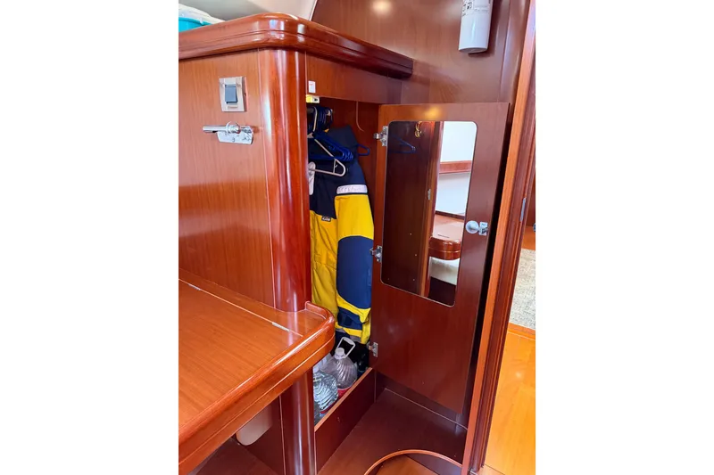 Slide: The Image of Wooden interior closet with mirror and hanging jacket on Beneteau Oceanis 523 yacht, 2006 model. - 58
