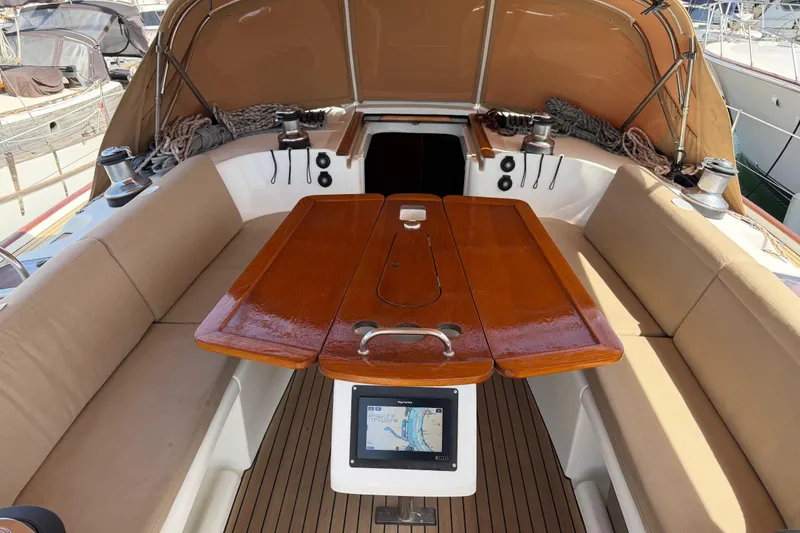 Slide: The Image of Cockpit of 2006 Beneteau Oceanis 523 sailboat with wooden table and beige seating. - 6