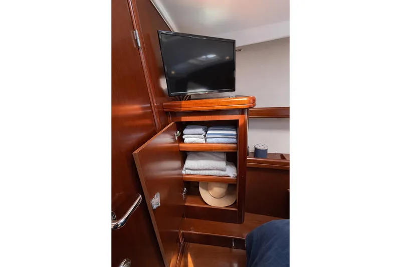 Slide: The Image of Interior of 2006 Beneteau Oceanis 523 yacht with TV and wooden storage shelves. - 62