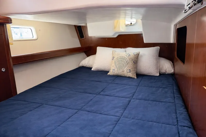 Slide: The Image of Cozy cabin interior of 2006 Beneteau Oceanis 523 with blue bedding and decorative pillows. - 67