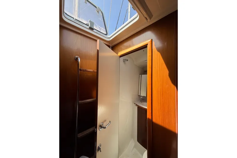 Slide: The Image of Interior view of 2006 Beneteau Oceanis 523 yacht bathroom with wooden finish and skylight. - 68