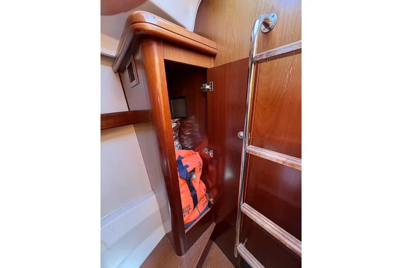 Slide: The Image of Wooden interior storage on 2006 Beneteau Oceanis 523 yacht with ladder and orange life jacket. - 70
