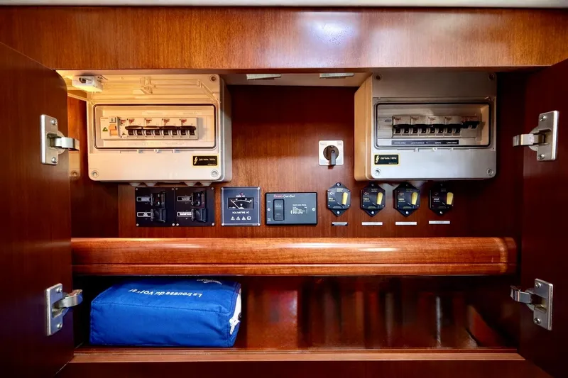 Slide: The Image of Electrical panel inside 2006 Beneteau Oceanis 523 yacht, featuring circuit breakers and controls. - 82