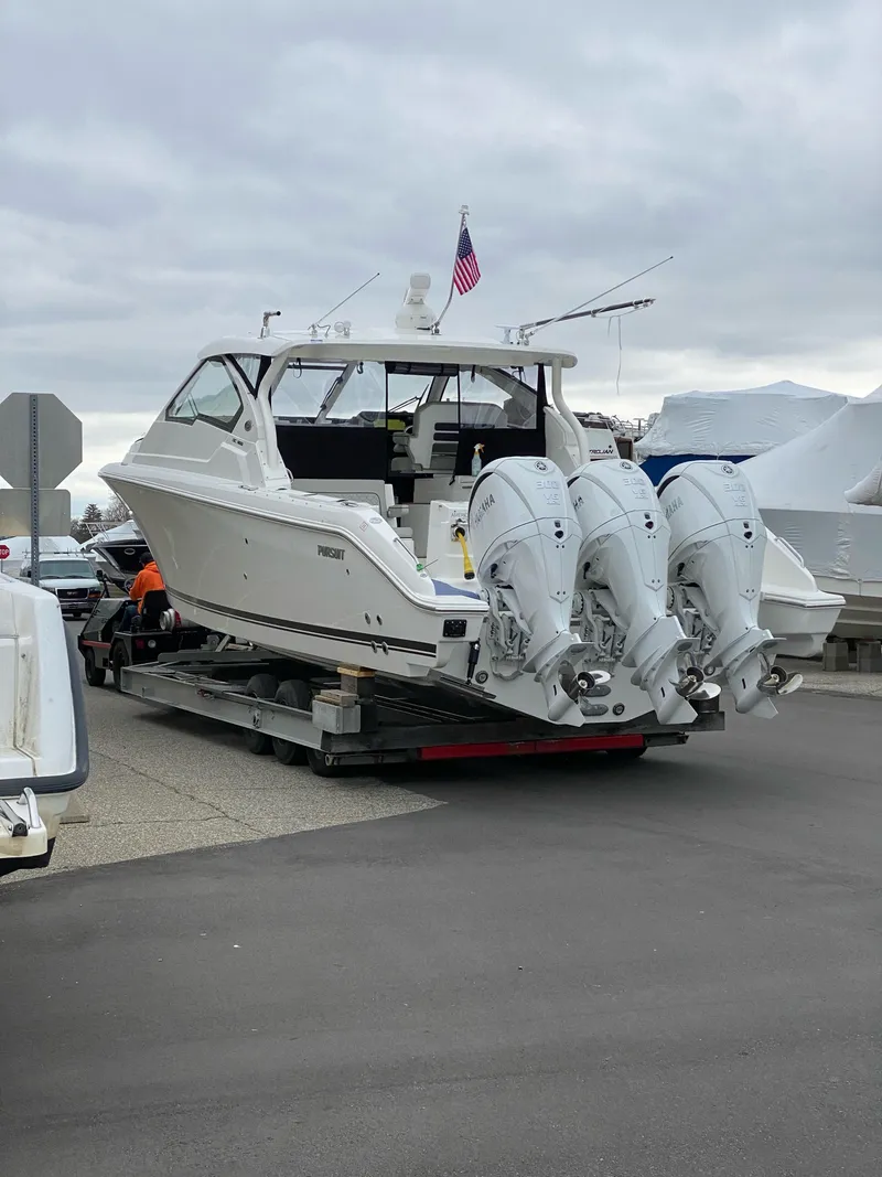 Slide: The Image of 2022 Pursuit DC 365 boat with triple outboard engines on trailer. - 3