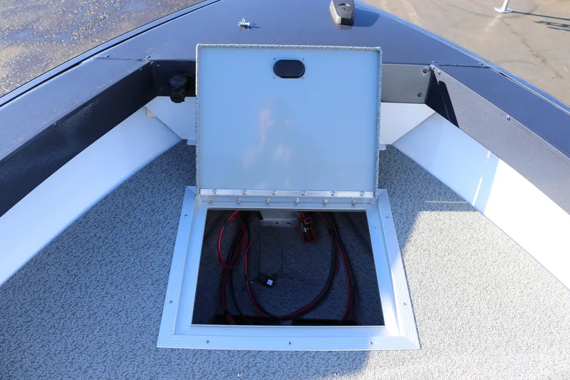 Slide: The Image of 2026 Smoker Craft Osprey 162 boat storage compartment with open hatch and visible wiring. - 11