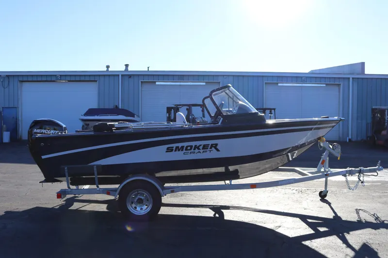 Slide: The Image of 2026 Smoker Craft Osprey 162 boat on trailer, parked outside industrial building. - 5