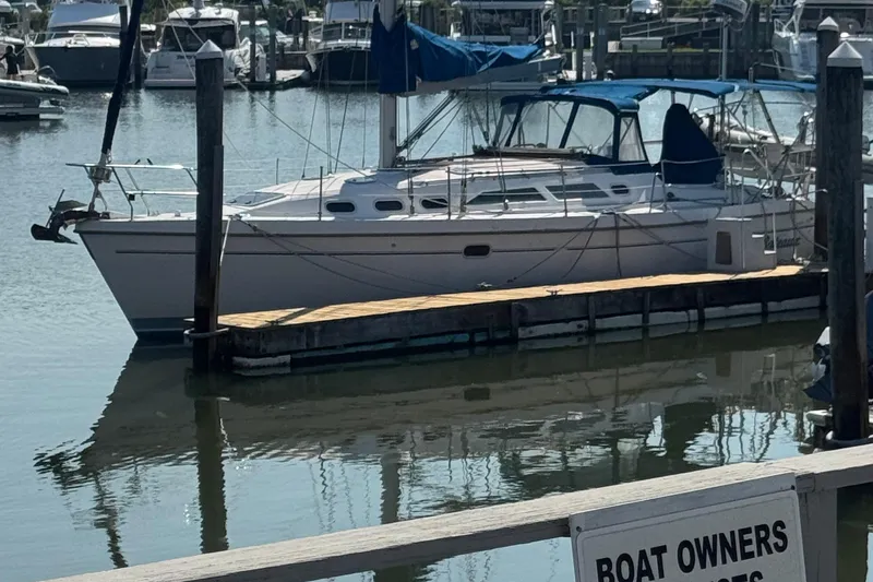 Slide: The Image of Catalina 380 sailboat docked in marina, 2000 model, with blue canopy. - 11