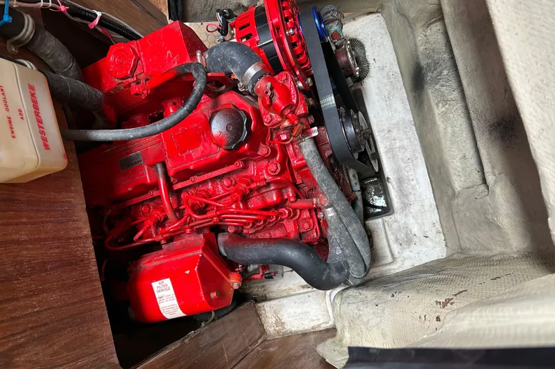 Slide: The Image of Red engine in a 2000 Catalina 380 sailboat, featuring hoses and components. - 12
