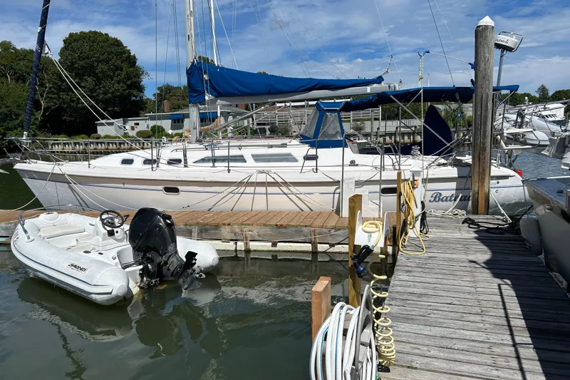 Slide: The Image of Catalina 380 sailboat from 2000 docked with inflatable dinghy nearby. - 15