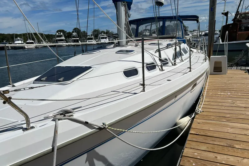 Slide: The Image of 2000 Catalina 380 sailboat docked at marina under clear blue sky. - 17