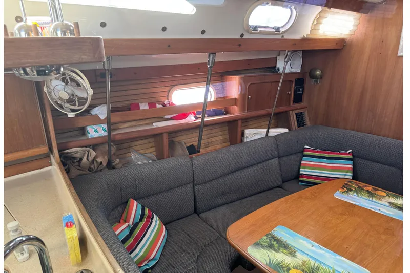 Slide: The Image of Cozy interior of 2000 Catalina 380 sailboat with striped cushions and wooden accents. - 21