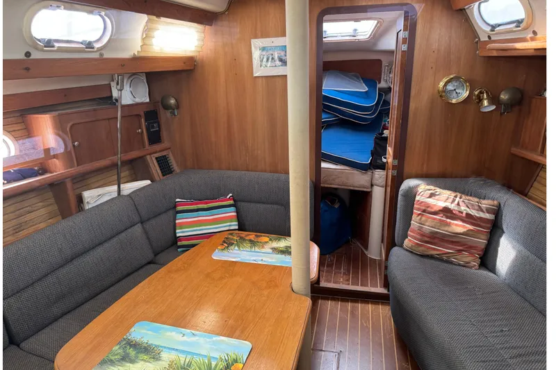 Slide: The Image of Cozy interior of 2000 Catalina 380 sailboat with wood paneling and cushioned seating. - 22