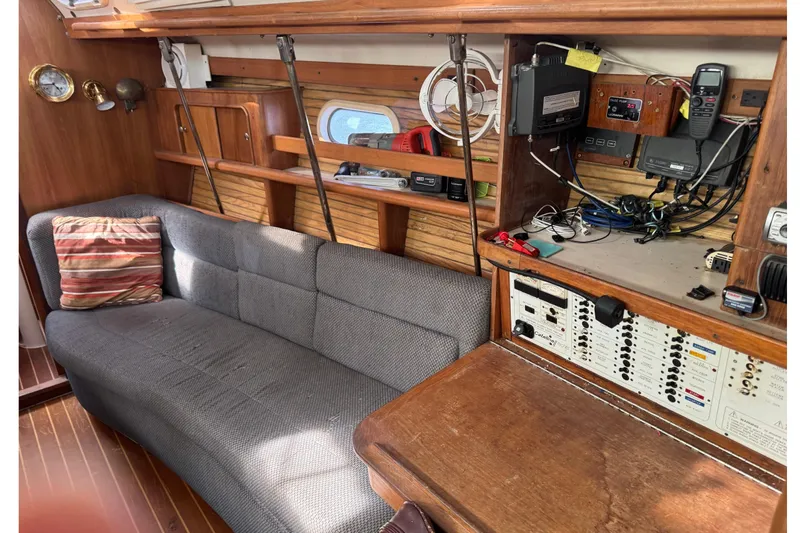 Slide: The Image of Interior of 2000 Catalina 380 sailboat with sofa, control panel, and wooden cabinetry. - 24