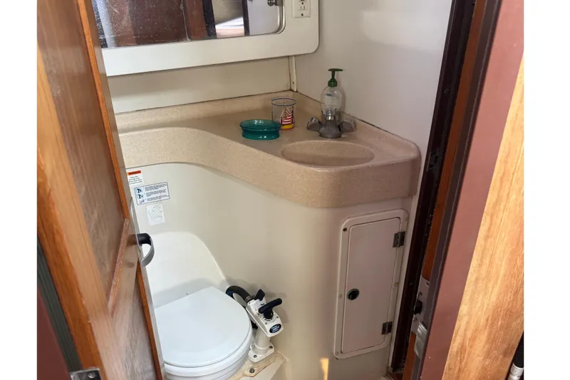 Slide: The Image of Compact bathroom in a 2000 Catalina 380 sailboat, featuring a toilet and sink. - 26