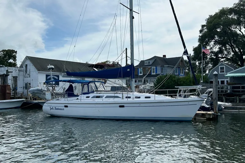 Slide: The Image of Catalina 380 sailboat docked at a marina, surrounded by buildings and trees. - 32
