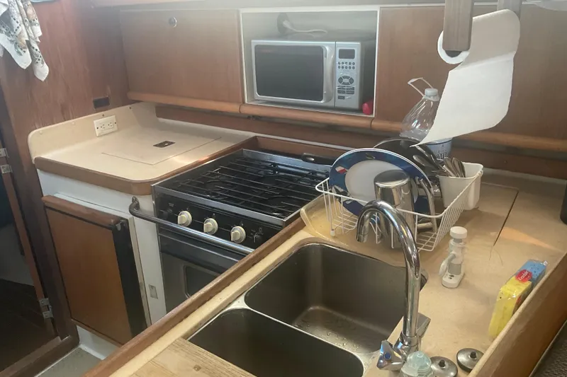 Slide: The Image of Galley kitchen in 2000 Catalina 380 sailboat with stove, sink, and microwave. - 6