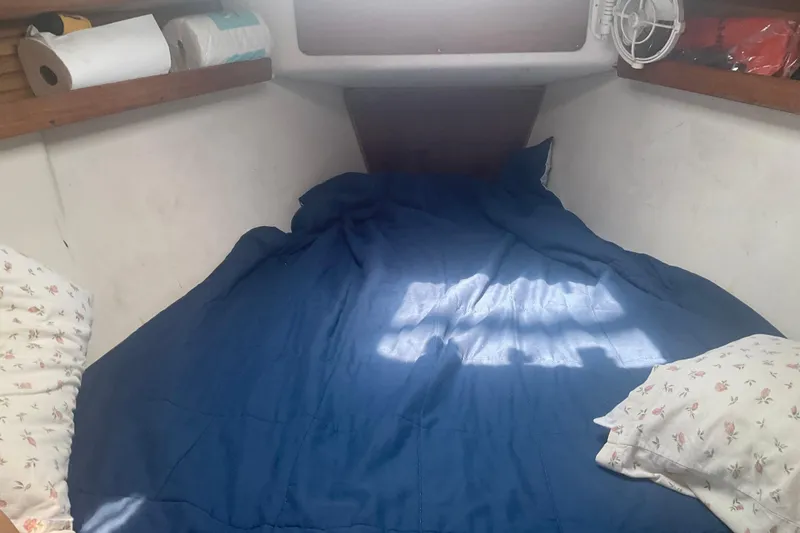 Slide: The Image of Cozy cabin interior of 2000 Catalina 380 sailboat with blue bedding and floral pillows. - 7