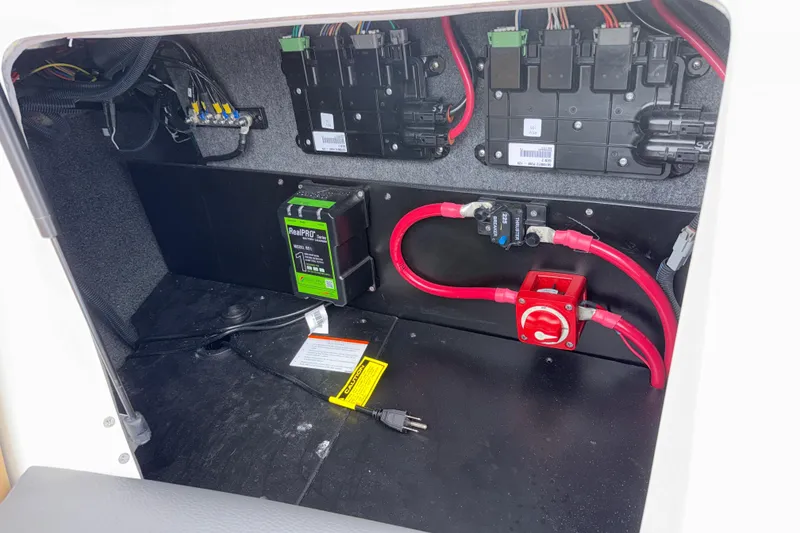 Slide: The Image of Electrical compartment of 2023 Tigé 23ZX boat with wiring and battery components. - 10