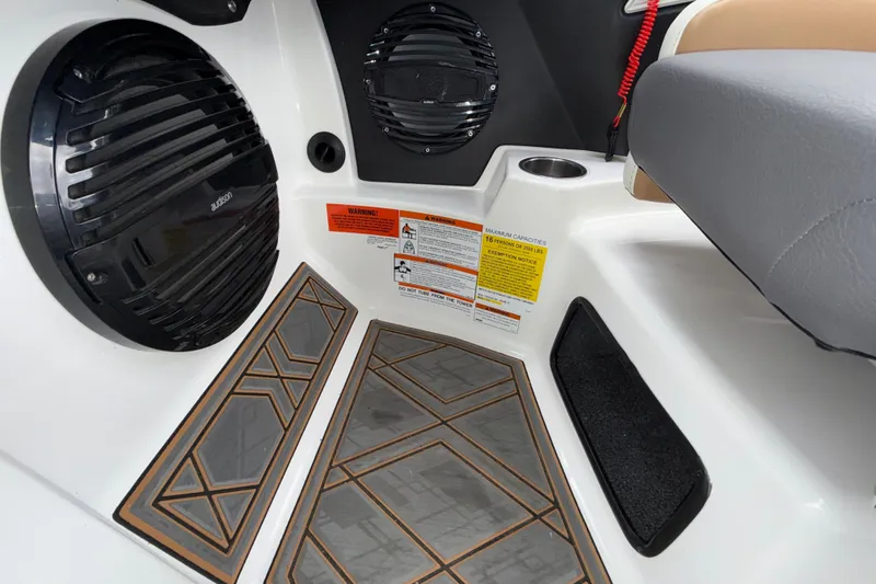 Slide: The Image of 2023 Tigé 23ZX boat interior with speakers, cup holder, and warning labels. - 15