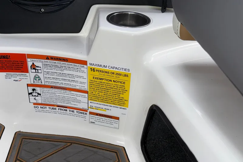 Slide: The Image of 2023 Tigé 23ZX boat capacity warning labels and cup holder detail. - 16