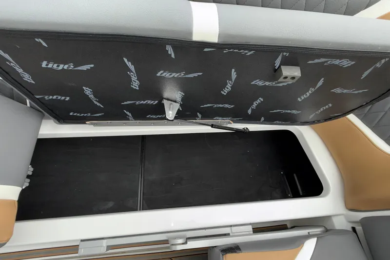 Slide: The Image of 2023 Tigé 23ZX boat storage compartment with open lid, showcasing interior space. - 18
