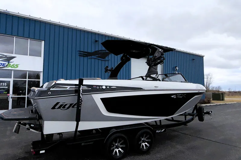 Slide: The Image of 2023 Tigé 23ZX boat on trailer outside blue building. - 3