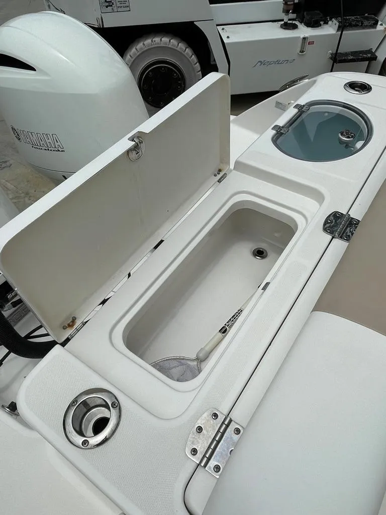 Slide: The Image of 2019 Robalo R242 Center Console boat with open storage compartment and livewell. - 10