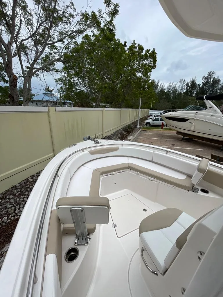 Slide: The Image of 2019 Robalo R242 Center Console boat with seating and storage, docked outdoors. - 17