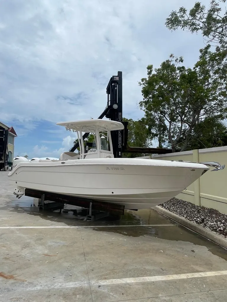 Slide: The Image of 2019 Robalo R242 Center Console boat on a lift. - 2