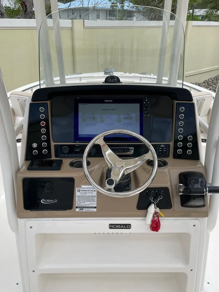 Slide: The Image of 2019 Robalo R242 Center Console boat dashboard with steering wheel and navigation display. - 24