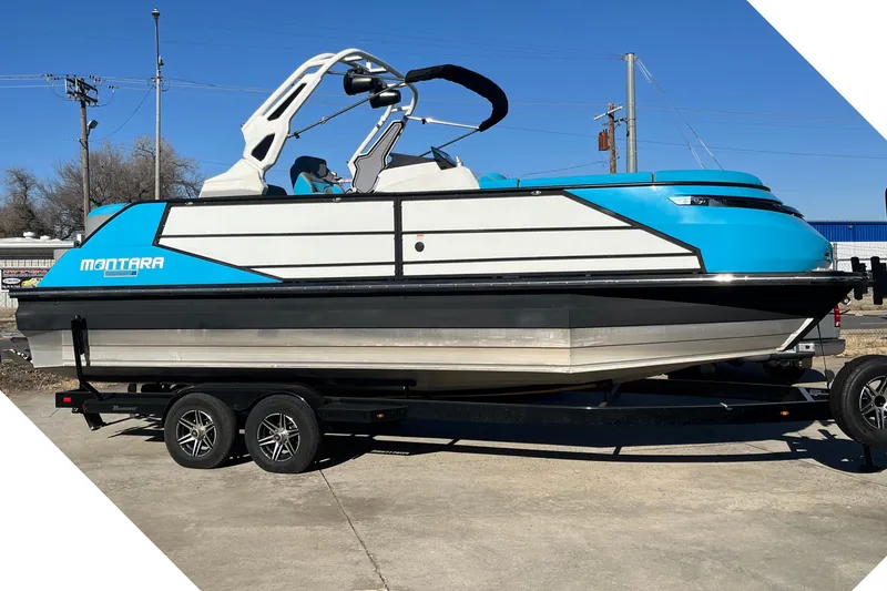 The Image of 2023 Montara 25 Surf Boss 2.0 CW boat on trailer, blue and white design. - 1