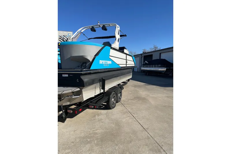 Slide: The Image of 2023 Montara 25 Surf Boss 2.0 CW boat on trailer, blue and gray design. - 5