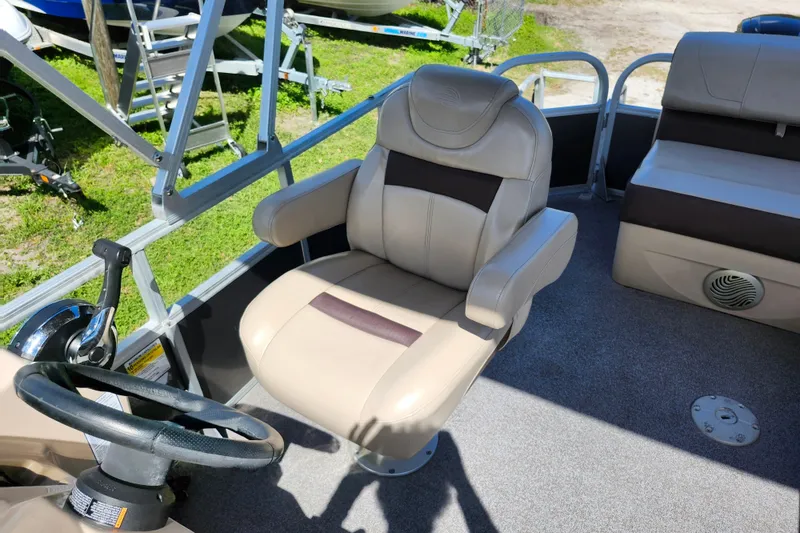 Slide: The Image of 2018 Sun Tracker Party Barge 20 DLX interior with captain's chair and steering wheel. - 21