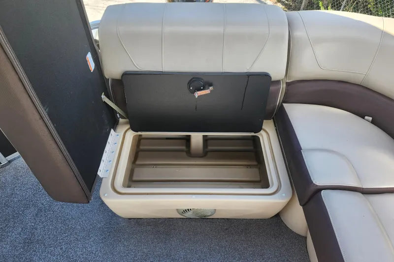 Slide: The Image of 2018 Sun Tracker Party Barge 20 DLX storage compartment with open seat revealing interior space. - 27