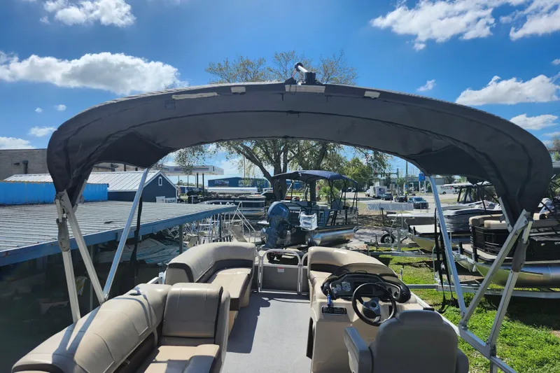 Slide: The Image of 2018 Sun Tracker Party Barge 20 DLX pontoon boat with canopy, docked under blue sky. - 29