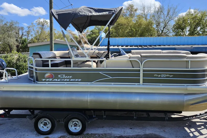 Slide: The Image of 2018 Sun Tracker Party Barge 20 DLX pontoon boat on trailer, outdoor setting. - 9