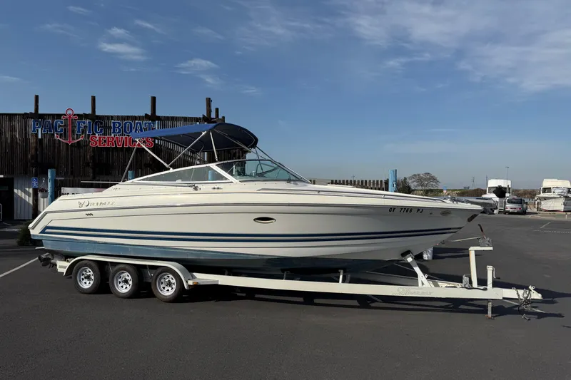 The Image of 2000 Formula boat on trailer at Pacific Boat Services under clear sky. - 1