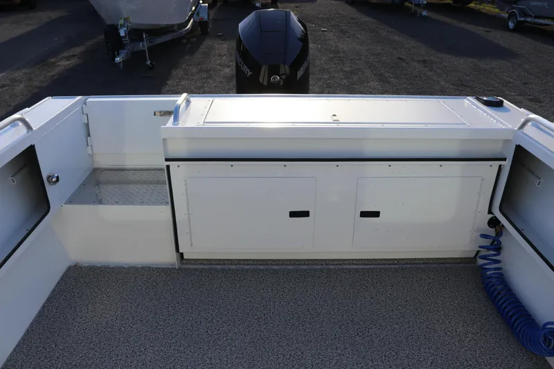 Slide: The Image of 2026 Alumaweld Intruder Outboard 22 boat interior with storage compartments and outboard motor. - 10