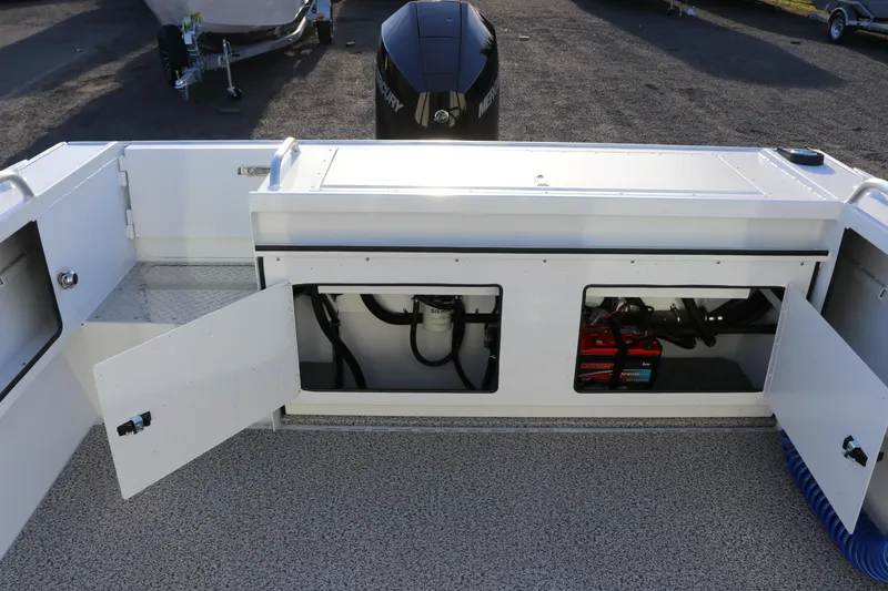 Slide: The Image of 2026 Alumaweld Intruder Outboard 22 boat interior with open storage compartments and visible engine components. - 15