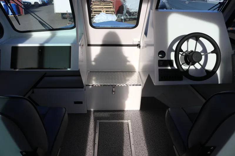 Slide: The Image of Interior of 2026 Alumaweld Intruder Outboard 22 boat, featuring steering wheel and seating. - 16