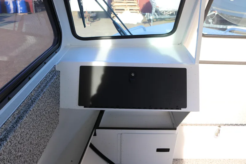 Slide: The Image of Interior view of 2026 Alumaweld Intruder Outboard 22 boat, featuring dashboard and storage compartment. - 19